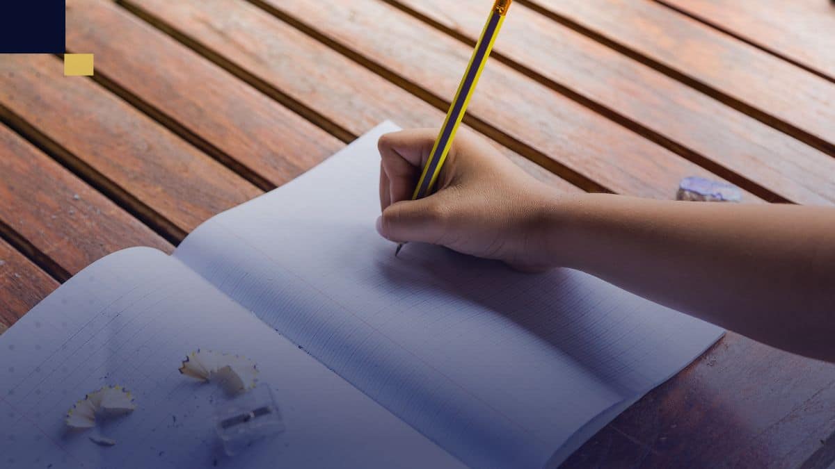 Mano escribiendo en cuaderno para estructurar el marco contextual de un proyecto académico