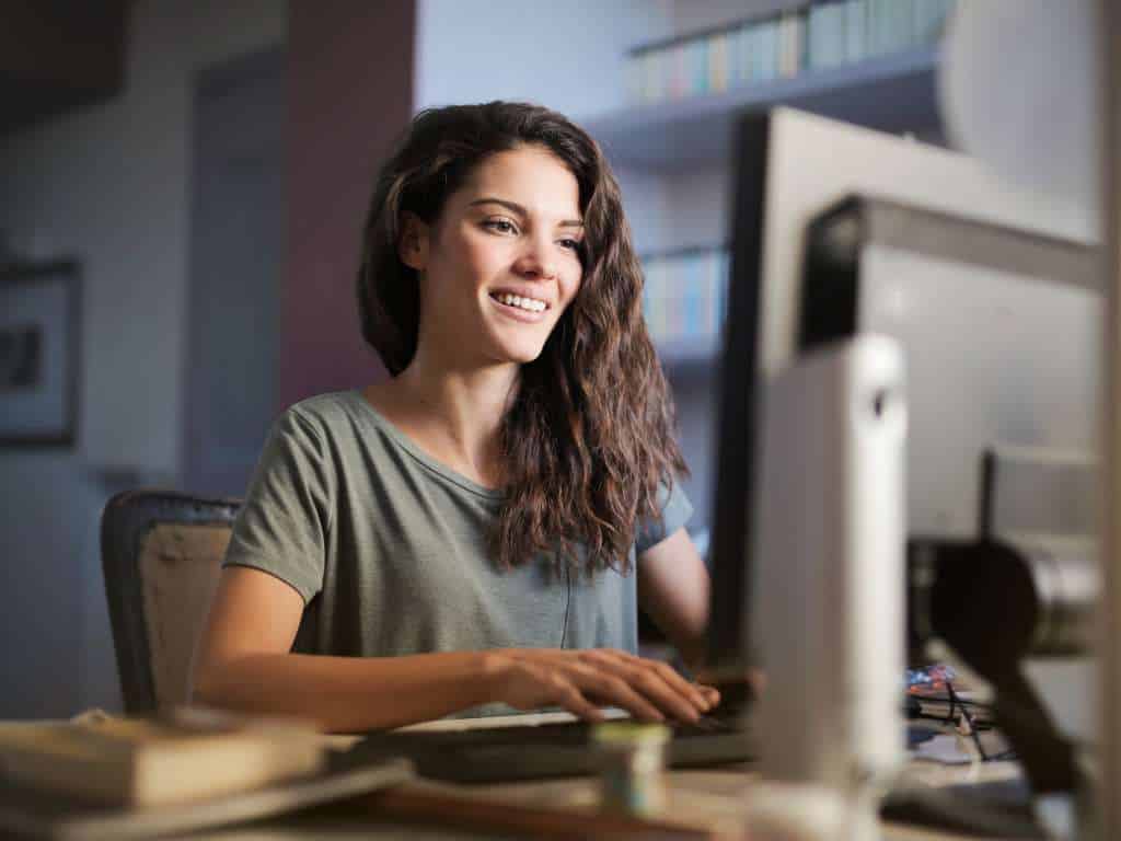 Redacción académica sobre tipos de investigación Joven investigadora redactando sobre tipos de investigación en entorno académico