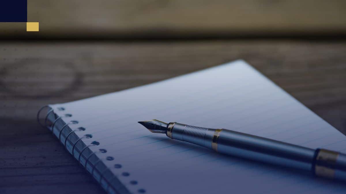 Cuaderno y bolígrafo listos para redactar ensayos con conectores textuales