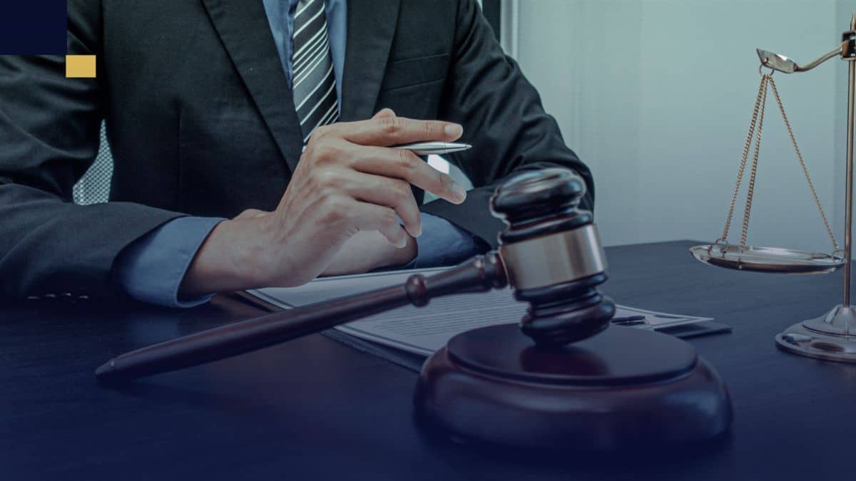 Abogado revisando documentos legales en despacho con mazo y balanza de la justicia.