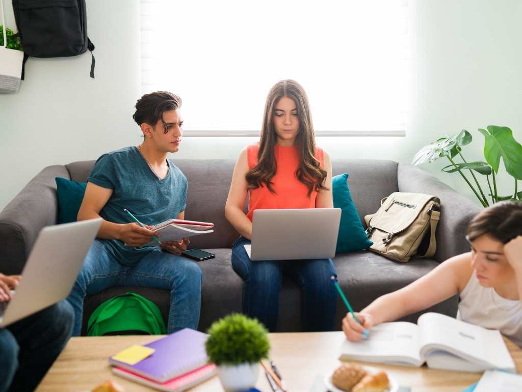 Investigación correlacional en equipo: estudiantes colaborando en el análisis de variables Grupo de estudiantes universitarios trabajando juntos en una sala de estudio, colaborando en el diseño y análisis de una investigación correlacional.