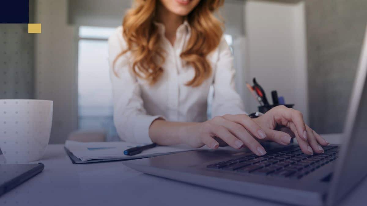 Estudiante universitario escribiendo la introducción de un ensayo en su laptop, con libros y apuntes sobre la mesa.