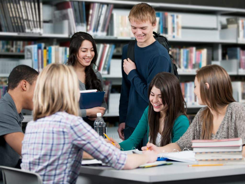 Variables dependientes e independientes: estudiantes revisando y subrayando información para su tesis Estudiantes universitarios revisando y subrayando información en apuntes y cuadernos, analizando variables para un proyecto académico.