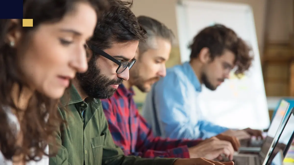 Estudiantes colaborando en la elaboración y redacción de un Trabajo Final de Máster (TFM) en aula universitaria