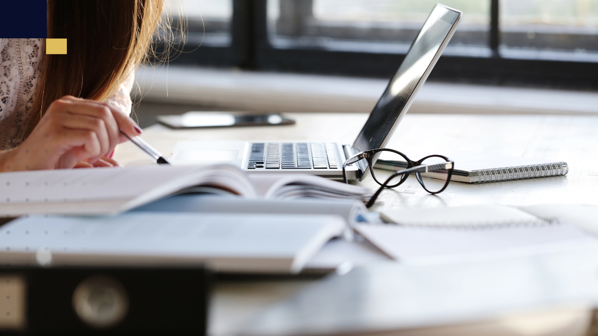 Estudiante investigando y tomando notas para construir el marco de referencia de una tesis académica