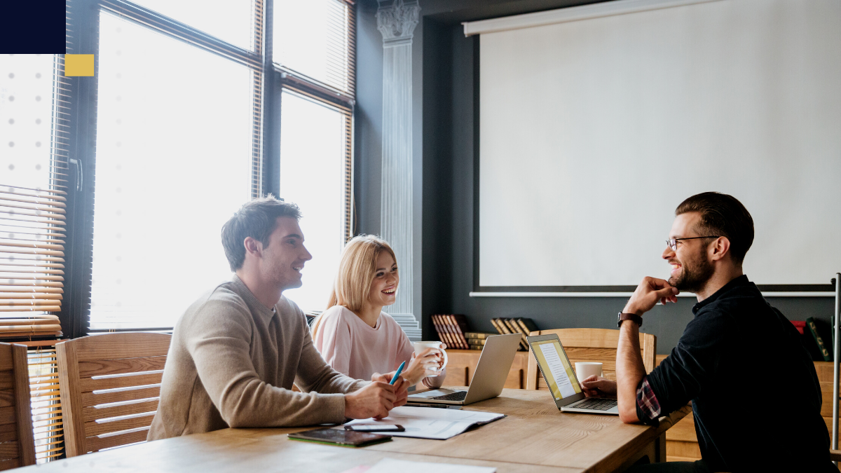 Emprendedor revisando gráficos y documentos en laptop, organizando la estructura y proyecciones de un plan de negocios en su espacio de trabajo.