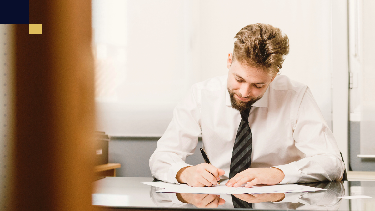 Abogado revisando documentos legales y tomando notas en una oficina, preparando el análisis para una tesis en Derecho Tributario.