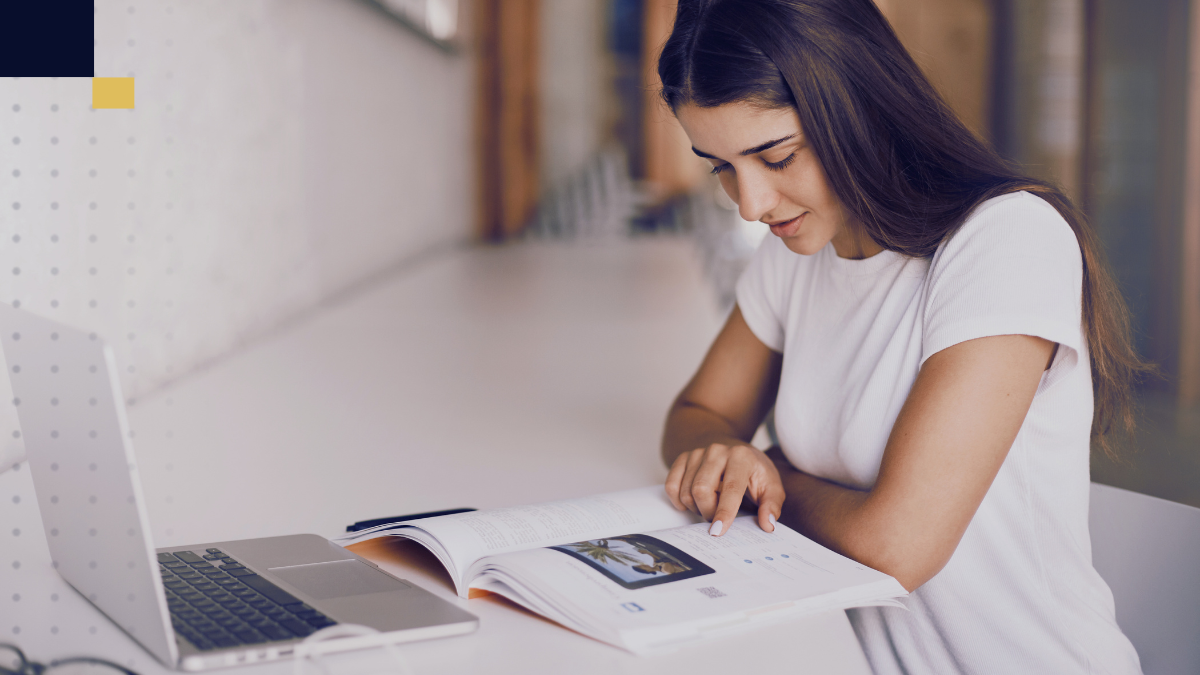 Estudiante investigando y tomando apuntes sobre estado del arte en tesis universitarias